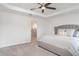 Comfortable main bedroom with tray ceilings, ceiling fan, and ensuite bathroom entrance at 6226 165Th E Dr, Parrish, FL 34219