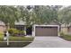 Charming single-story home featuring a well-manicured lawn, mature trees, and a two-car garage at 6517 Summer Cove Dr, Riverview, FL 33578