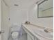Well-lit bathroom featuring a toilet, framed mirror, white marble countertop, and sink at 7400 Sun Island S Dr # 412, South Pasadena, FL 33707