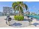 Outdoor grill area with palm trees, covered picnic tables, boat docks, and a tennis court at 7400 Sun Island S Dr # 412, South Pasadena, FL 33707