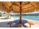 Waterside picnic area featuring wooden tables and a tiki hut offering shade and relaxation at 7400 Sun Island S Dr # 412, South Pasadena, FL 33707