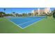 Outdoor tennis courts ready for a match, surrounded by palm trees and under a bright blue sky at 7400 Sun Island S Dr # 412, South Pasadena, FL 33707