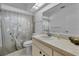 Cozy bathroom features a vanity, toilet, and shower with patterned curtain at 7708 Fairlawn Dr, Hudson, FL 34667