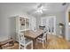 Charming dining area with ceiling fan, wood floors, white shelving, and double doors leading to back at 7708 Fairlawn Dr, Hudson, FL 34667