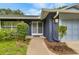 Close up of the front entrance with well maintained bushes and a walkway to the front door at 7708 Fairlawn Dr, Hudson, FL 34667