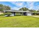 Charming single-story home with well-maintained lawn, mature trees, and a lush landscape at 7708 Fairlawn Dr, Hudson, FL 34667