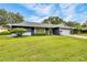 Charming single-story home with well-maintained lawn, mature trees, and a lush landscape at 7708 Fairlawn Dr, Hudson, FL 34667