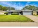 Charming single-story home with well-maintained lawn, mature trees, and an attached two car garage at 7708 Fairlawn Dr, Hudson, FL 34667