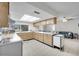 Open kitchen with abundant wood cabinetry and a view to the living room at 7708 Fairlawn Dr, Hudson, FL 34667