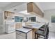 Bright kitchen with wood cabinets, a breakfast bar with stools, and white appliances at 7708 Fairlawn Dr, Hudson, FL 34667