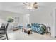 Spacious living room features neutral tile flooring, white wainscoting, and a unique, colorful couch at 7708 Fairlawn Dr, Hudson, FL 34667
