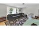 Comfortable living room with plush gray sectional sofa, large windows, and a decorative rug at 7708 Fairlawn Dr, Hudson, FL 34667