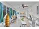 Bright sunroom features tile flooring and large windows showcasing backyard views at 7708 Fairlawn Dr, Hudson, FL 34667