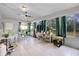 Bright sunroom features tile flooring, large windows with backyard views, and a ceiling fan at 7708 Fairlawn Dr, Hudson, FL 34667