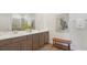 Elegant bathroom featuring a double vanity with granite countertops, a wooden bench and a glass shower at 7747 Wheat Stone Dr, Zephyrhills, FL 33540