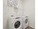 Laundry room features a Whirlpool washer and dryer, as well as a wire shelf for storage at 7747 Wheat Stone Dr, Zephyrhills, FL 33540