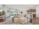 Open-concept living area with a large sectional sofa, kitchen with a breakfast bar, and backyard access at 7747 Wheat Stone Dr, Zephyrhills, FL 33540