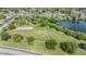 Scenic aerial view of a park with a playground, basketball court, lake and walking path at 9115 Panda Ln, Port Richey, FL 34668