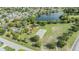 Overhead view of community park, featuring playground, basketball court, and a serene lake at 9115 Panda Ln, Port Richey, FL 34668