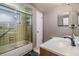 Bathroom featuring a shower-tub combination with glass door, retro tile, and modern vanity at 9115 Panda Ln, Port Richey, FL 34668