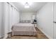 Cozy bedroom featuring light wood flooring, white walls, and a bed with floral patterned bedding at 9115 Panda Ln, Port Richey, FL 34668