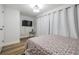 Light and airy bedroom with wood flooring, a TV, and a bed with floral patterned bedding at 9115 Panda Ln, Port Richey, FL 34668