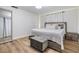 Bright bedroom featuring a gray accent bed frame, luxury vinyl floors, neutral tones, and white curtains at 9115 Panda Ln, Port Richey, FL 34668