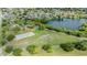 Aerial view of a park with a basketball court, playground and open space near the neighborhood lake at 9115 Panda Ln, Port Richey, FL 34668