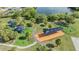 Aerial view showcases a community park with playgrounds, walking paths, and recreation areas near a serene pond at 9115 Panda Ln, Port Richey, FL 34668