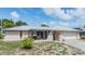 Charming home with a pergola-covered patio, gated entry, and a fresh exterior paint job under a blue sky at 9115 Panda Ln, Port Richey, FL 34668