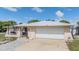 Charming single-story home with a well-maintained lawn, arched entryway, and an attached two-car garage at 9115 Panda Ln, Port Richey, FL 34668