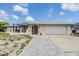 Charming single-story home with a well-maintained lawn, arched entryway, and an attached two-car garage at 9115 Panda Ln, Port Richey, FL 34668