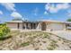 Charming home with a pergola-covered patio, gated entry, and a fresh exterior paint job under a blue sky at 9115 Panda Ln, Port Richey, FL 34668
