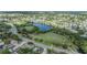 Aerial view showcases the neighborhood with a lakeside park surrounded by homes and community roadways at 9115 Panda Ln, Port Richey, FL 34668