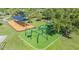 Aerial view of a modern playground with climbing structures, sunshades, and manicured green space for Gathering fun at 9115 Panda Ln, Port Richey, FL 34668
