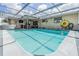 Outdoor swimming pool with a large deck and screened enclosure at 9115 Panda Ln, Port Richey, FL 34668