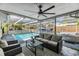 Covered outdoor living space with large seating area and view of the swimming pool at 9115 Panda Ln, Port Richey, FL 34668
