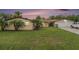 Charming single-story home featuring a two-car garage, well-manicured lawn, and lush tropical landscaping at 9220 Mcintosh Rd, Dover, FL 33527