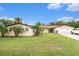 Charming single-story home featuring a two-car garage, well-manicured lawn, and lush tropical landscaping at 9220 Mcintosh Rd, Dover, FL 33527