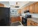 Efficient kitchen with wooden cabinets, black appliances, and plenty of counter space at 9737 86Th Ave, Seminole, FL 33777