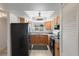 Well-lit kitchen featuring wooden cabinets, black appliances, and tile flooring at 9737 86Th Ave, Seminole, FL 33777