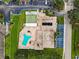 An aerial view of the complex featuring a pool, shuffleboard court, parking, and surrounding landscaping at 9945 47Th N Ave # 210, St Petersburg, FL 33708