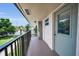 Balcony view of a condominium featuring gray door, black metal railing, and view of green space and landscaping at 9945 47Th N Ave # 210, St Petersburg, FL 33708