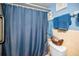 Bathroom featuring a toilet with a blue shower curtain and tiled walls at 9945 47Th N Ave # 210, St Petersburg, FL 33708