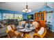 Dining area featuring blue walls, hardwood floors, area rug, and access to living room with natural light at 9945 47Th N Ave # 210, St Petersburg, FL 33708