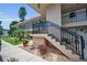 Exterior view of a two-story building featuring well-maintained landscaping and staircases with black metal railings at 9945 47Th N Ave # 210, St Petersburg, FL 33708