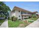 Inviting two-story condo with a balcony, manicured lawn and walkway under a blue sky at 9945 47Th N Ave # 210, St Petersburg, FL 33708