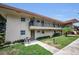 Inviting condo exterior with a cozy entrance and lush green lawn with nearby seating area at 9945 47Th N Ave # 210, St Petersburg, FL 33708
