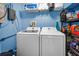 Efficient laundry room with front loading washer and dryer and shelving storage at 9945 47Th N Ave # 210, St Petersburg, FL 33708