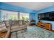 A well-lit living room with stylish furnishings, blue walls, hardwood floors, and an area rug at 9945 47Th N Ave # 210, St Petersburg, FL 33708